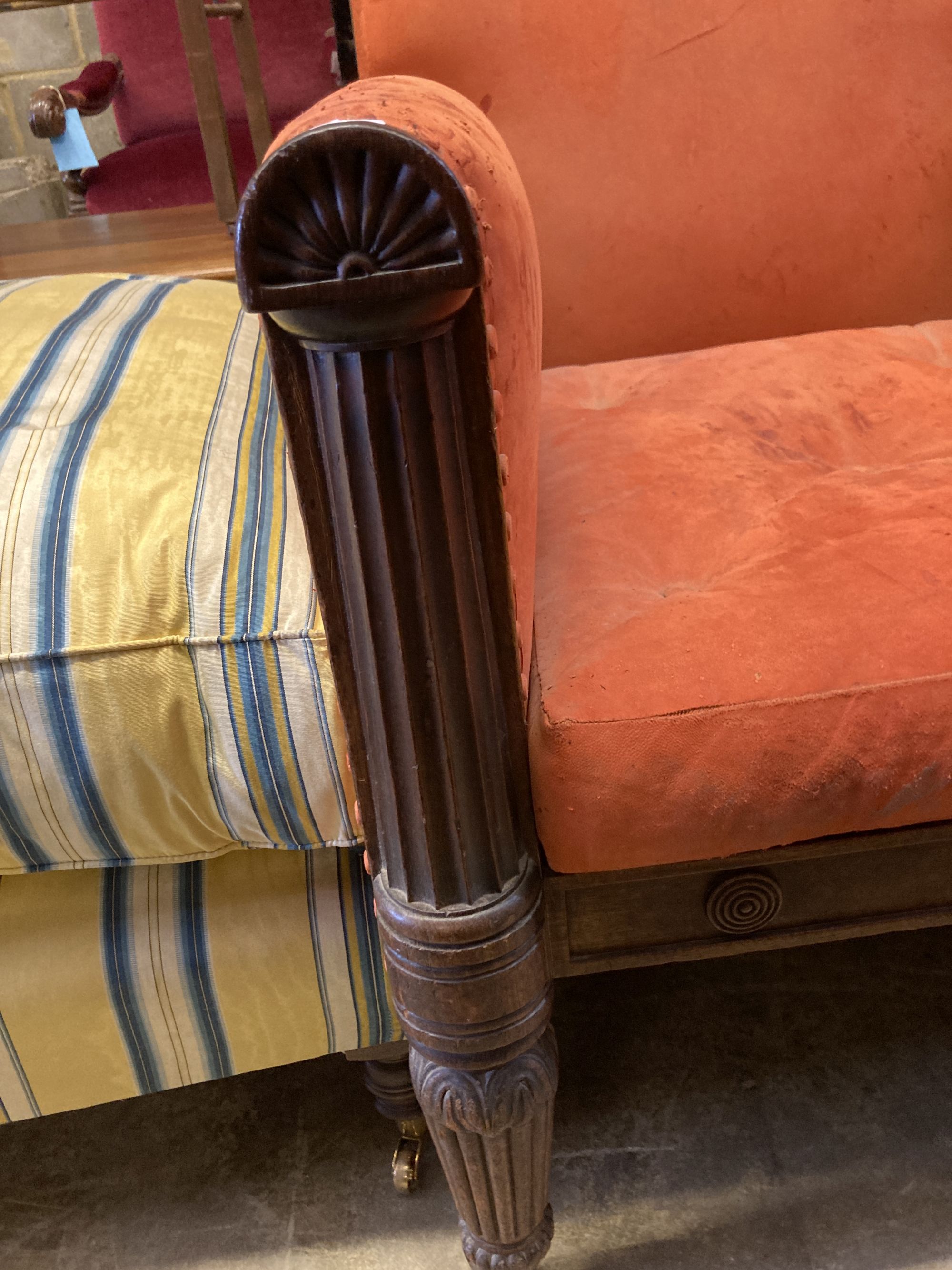 A George IV carved mahogany library armchair upholstered in faded red leather, width 70cm, depth 80cm, height 100cm